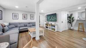 A modern living room with a grey sectional sofa, a wooden coffee table, and a flat-screen TV mounted on the wall. - Artful Heaven: Sleeps up to 6, Private Luxury ! (Pueblo)