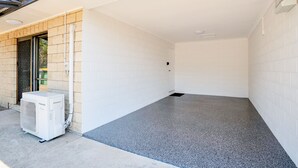 A clean, empty room with white tiled walls and a grey speckled floor. - Gold Rush Apartments (Monkland)