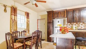 A kitchen with wooden cabinets, a white countertop, and a ceiling fan.