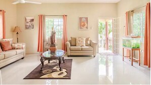 A spacious living room with a sofa, a coffee table, and a fish tank.