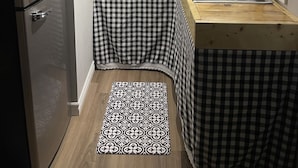 A compact kitchen with a refrigerator, microwave, and sink.