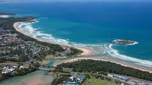 An aerial view of a coastal town with a beach, a small island, and a bridge connecting to the mainland. - Coffs Harbour Beach House (Coffs Harbour)