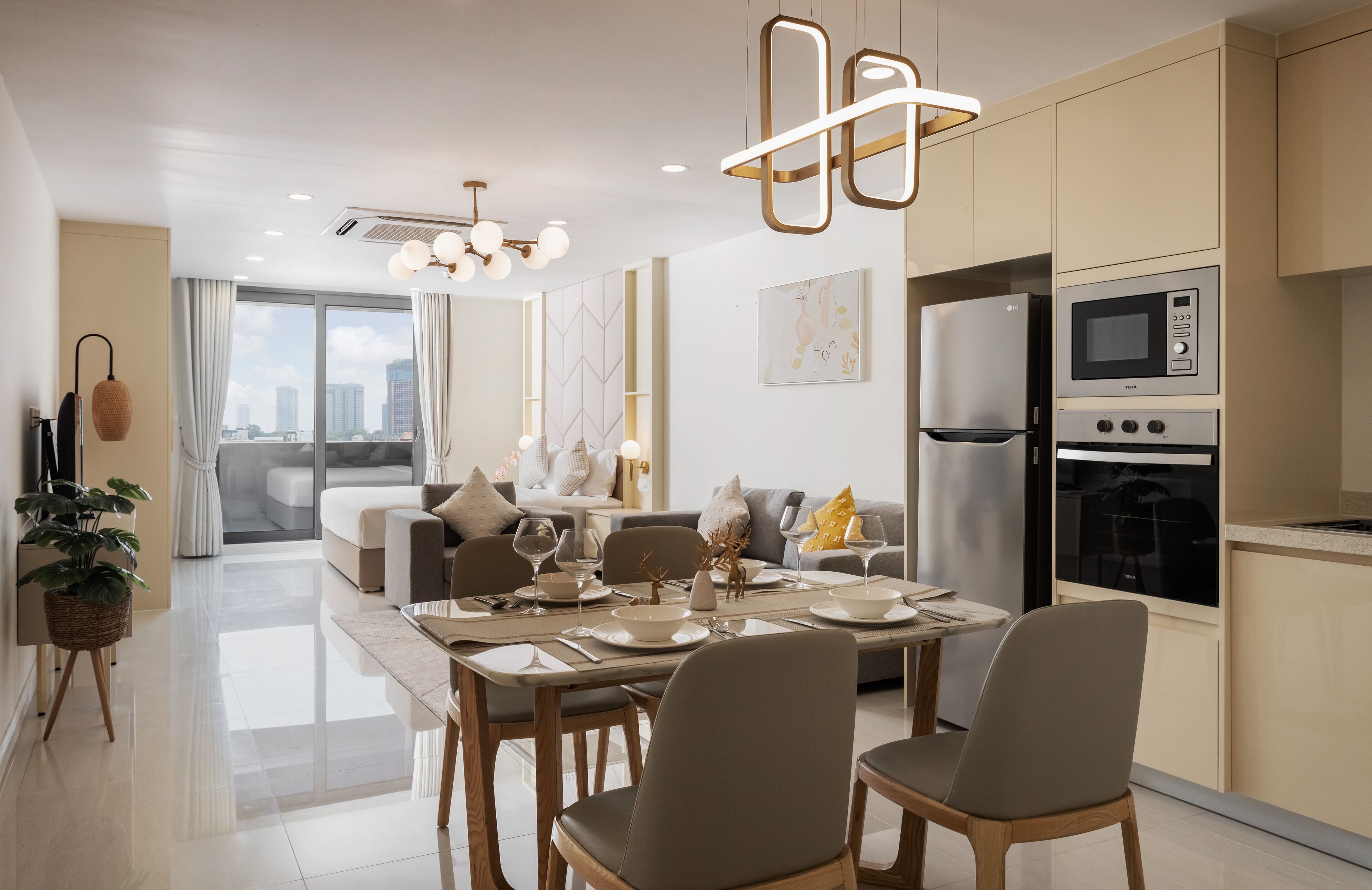 A modern kitchen with built-in appliances, a dining area with a table set for four, and a view of the city through large windows.