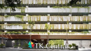 A modern building with horizontal concrete terraces covered in greenery, a logo with a colorful star, and a sign reading "TK Central".
