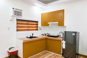 Een oven, een kookplaat, kookgerei, borden en bestek, een eettafel