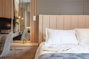 A modern hotel room with a bed, a desk, and a television. - North Medellin Luxury Cozy and Classy Apartment near Downtown (Medellín)