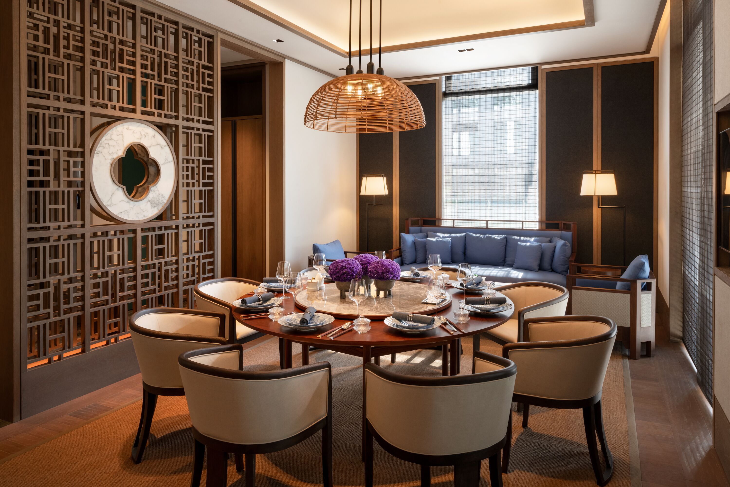 A modern dining area with a round table, chairs, and a decorative centerpiece.