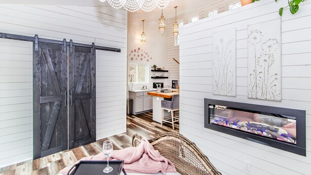 A cozy living area with a dining table, wicker chair, and a fireplace.