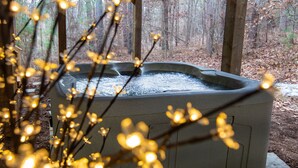 A hot tub in a forested area with wooden decking.