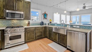 Una cucina moderna con elettrodomestici in acciaio inossidabile, pensili in legno e un'ampia finestra con vista.