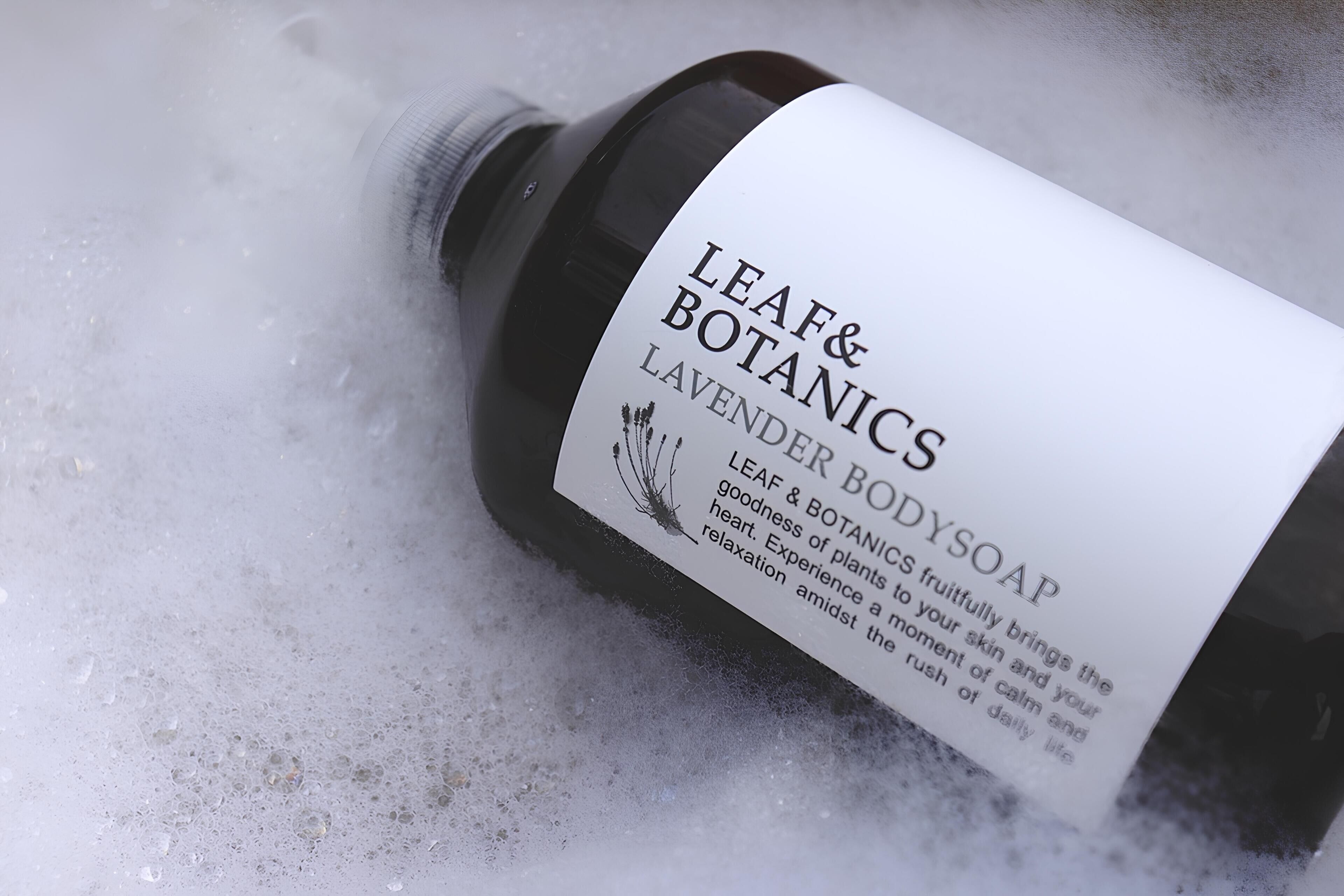 Una botella de Jabón de Cuerpo Lavanda de Leaf & Botanics con una etiqueta que describe sus beneficios.