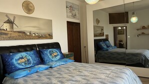 A bedroom with a bed, a large mirror, and artwork on the walls. - Casa Iose by Interhome (Torrazza)
