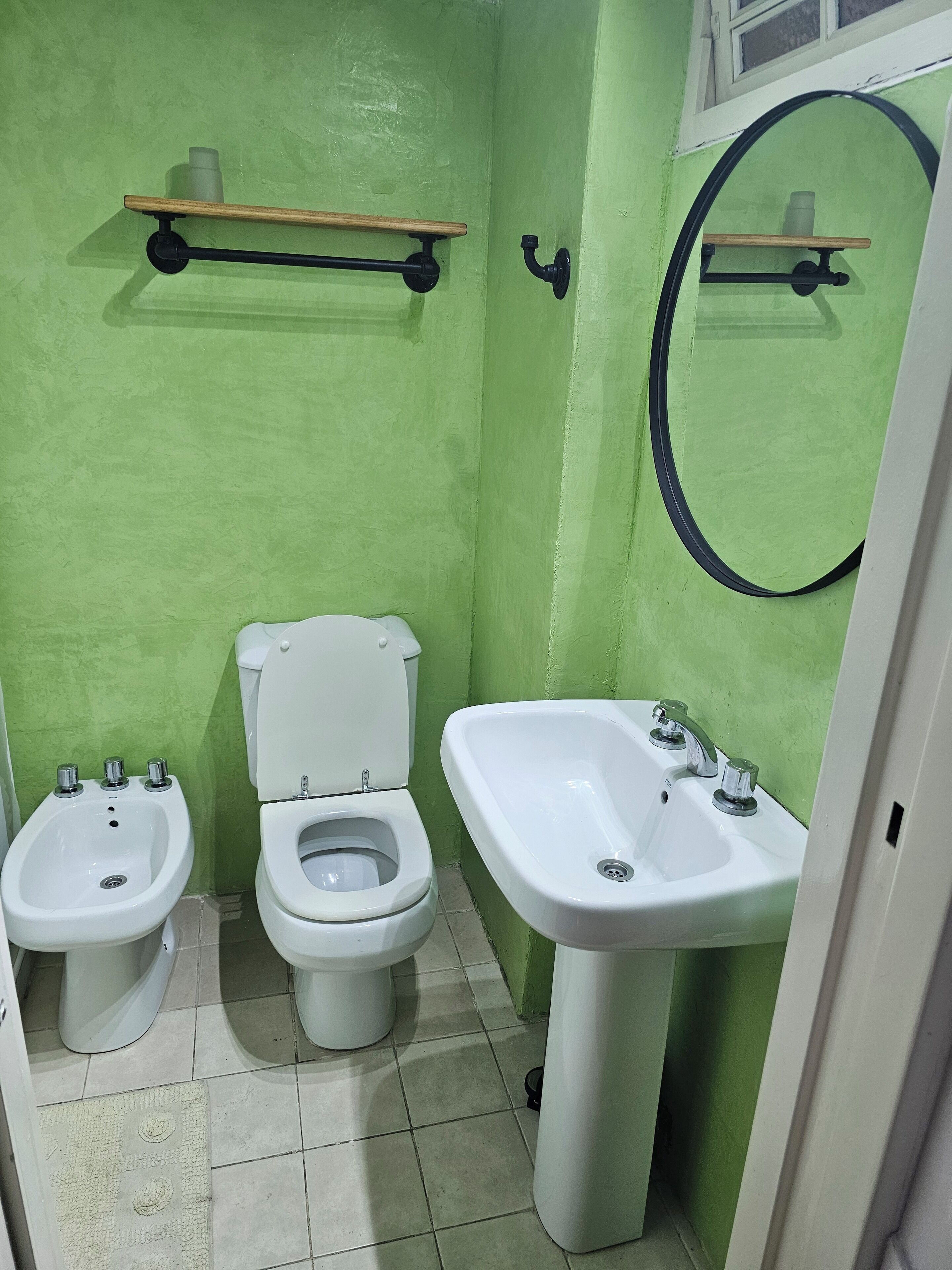 A small bathroom with a toilet, bidet, and sink.