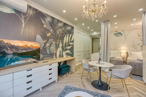A modern living room with a TV, a dining area, and a bedroom. - Boutique Downtown Studio with Balcony  1 (Zagreb)