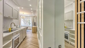 A modern kitchen with white cabinetry, a wooden countertop, and a built-in oven.