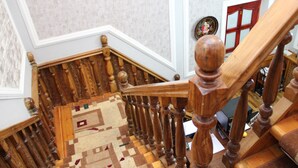A wooden staircase with a patterned carpet and a door with glass panels. - BEST GUESTHOUSE (Tashkent)