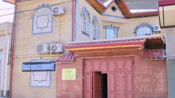A building with a sign reading "Best Guesthouse" and a door with a sign indicating it is a family guesthouse.