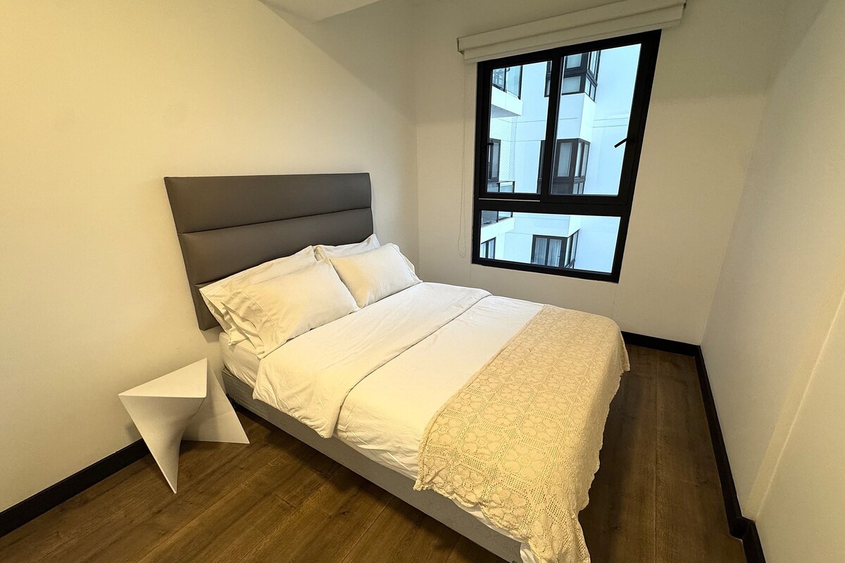 Une chambre à coucher avec un lit, une fenêtre et un plancher en bois.