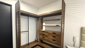 Un dormitorio con cama, mesita de noche, armario y zapatero.