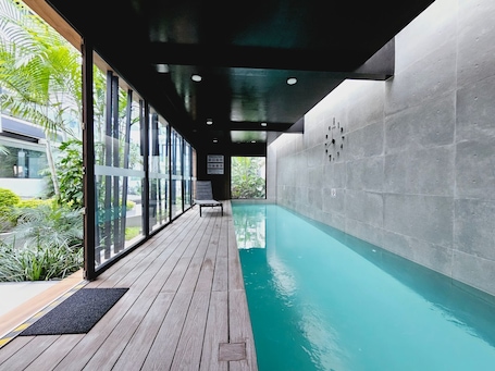 Una piscina techada, sillones reclinables de piscina