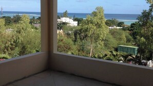 Ein Balkon mit Blick auf das Meer und die umliegende Natur.