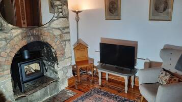 Smart-tv, een open haard, boeken en een stereo
