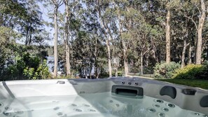 A hot tub with a view of a lake and trees. - Aria Shores - Your Lakeside Haven (Kings Point)
