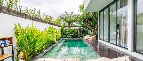 Una piscina al aire libre, sillones reclinables de piscina