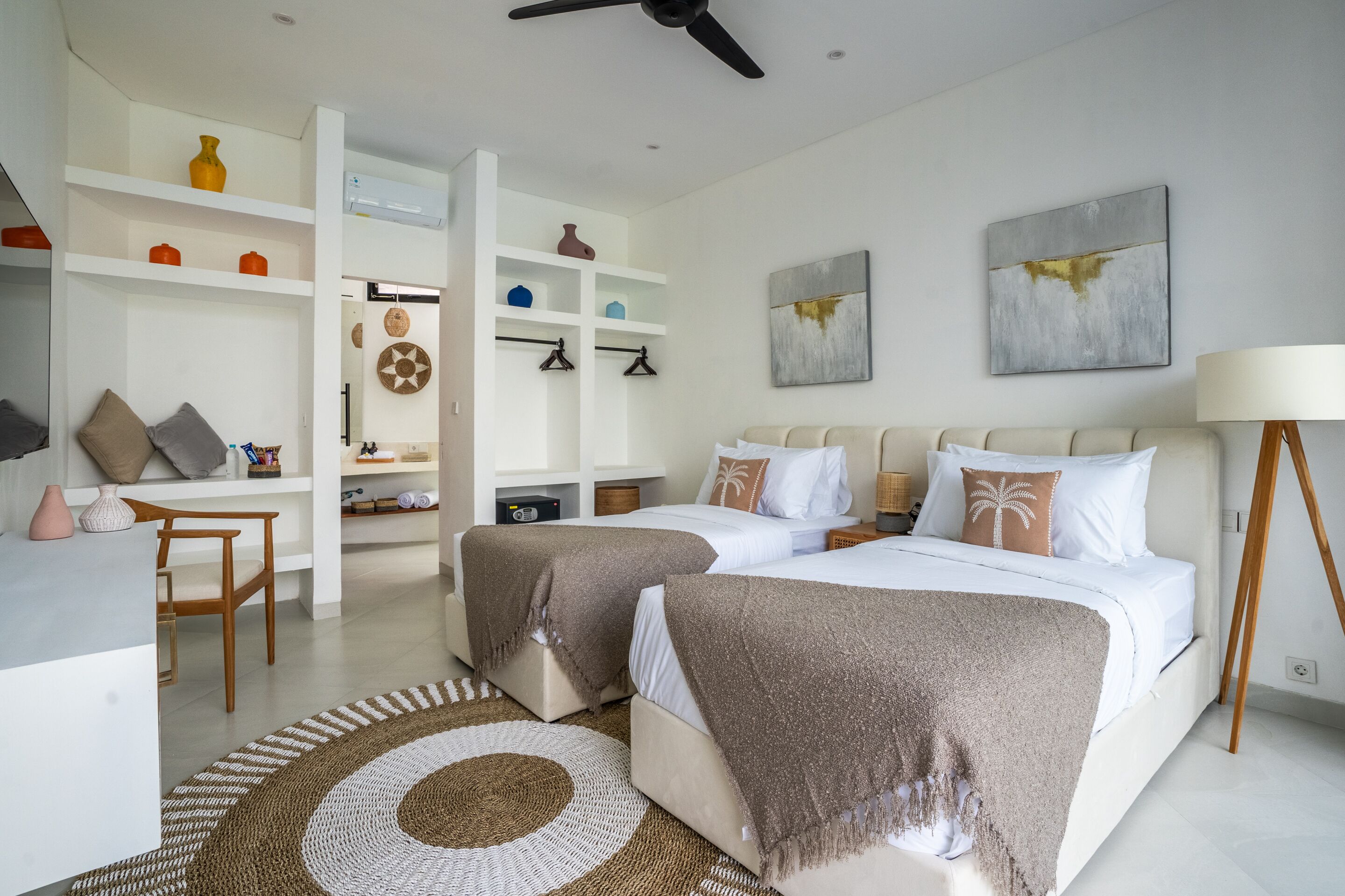 Una habitación de hotel moderna con dos camas, un escritorio y una zona de estar.