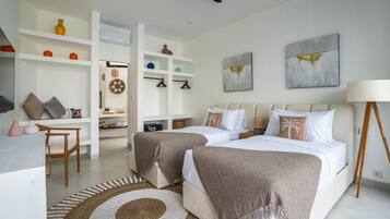Una habitación de hotel moderna con dos camas, un escritorio y una zona de estar.