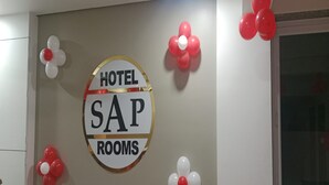 A wall sign with "HOTEL SAP ROOMS" surrounded by red and white balloons. - Hotel SAP (Kalol)
