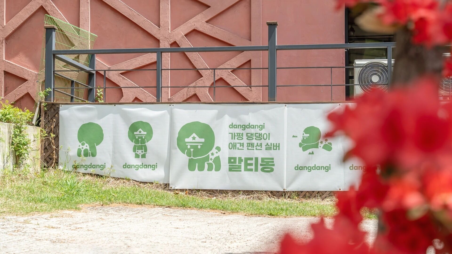 Un cartel con texto y símbolos verdes, fijado en una pared con diseño geométrico.