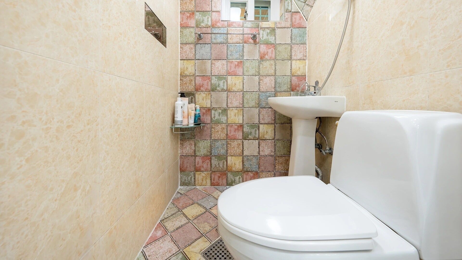 A bathroom with a toilet, sink, and shower.