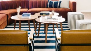 A modern living room with a sectional sofa, two round coffee tables, and a striped rug. - Expansive Wine Country Estate | Pool + Hot Tub | Sleeps 20 | Quiet Retreat (Temecula)