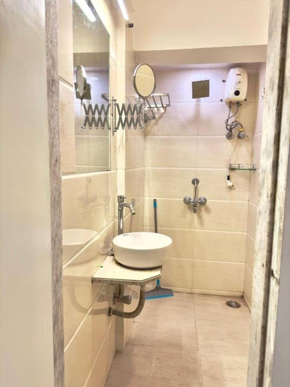 A small bathroom with a sink, mirror, and shower.