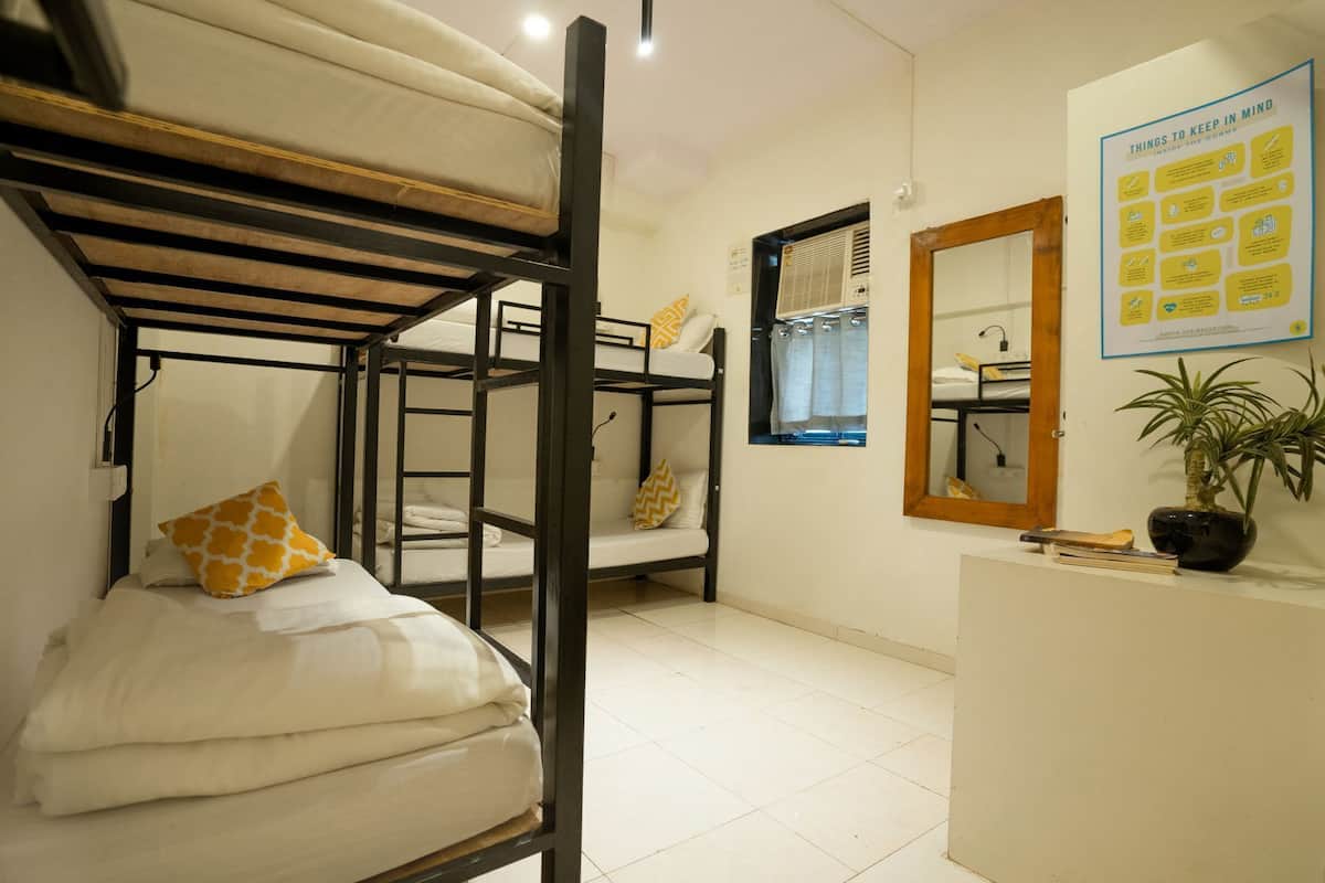 A bunk bed room with a mirror and a poster on the wall.