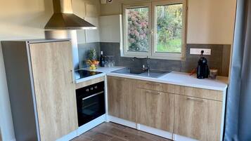 Køleskab, ovn, kaffe-/temaskine, køkkentøj/tallerkener/redskaber