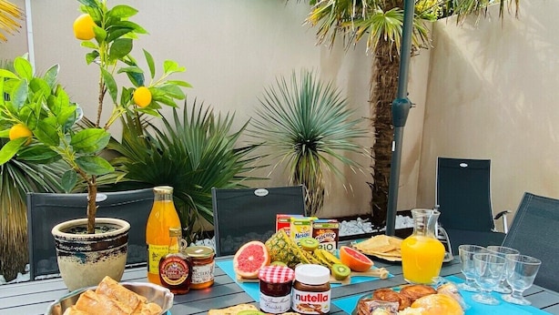 Una mesa al aire libre con diversos alimentos, como pan, frutas y salsas.