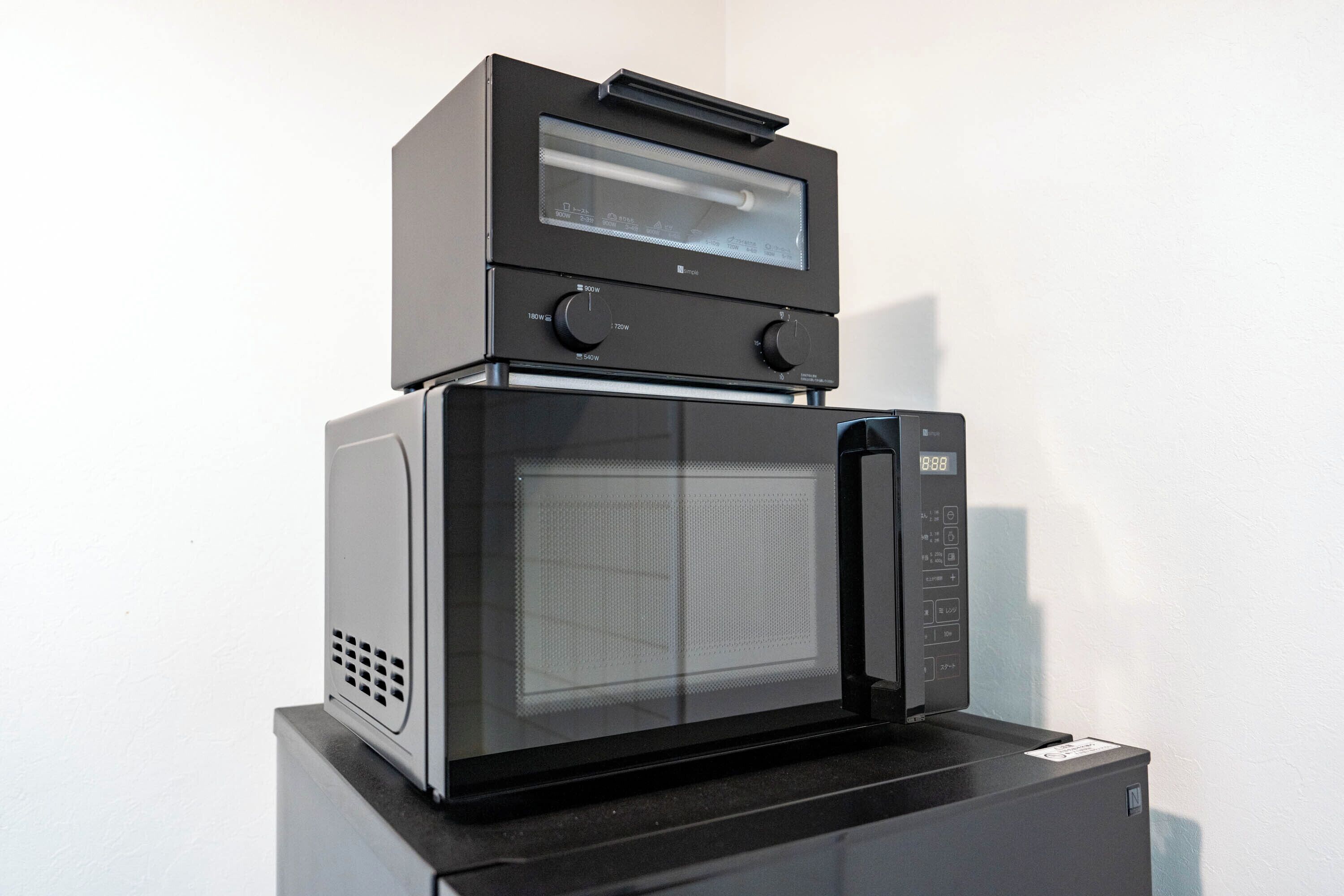 A compact, modern kitchen setup with a built-in microwave and oven on a single unit.