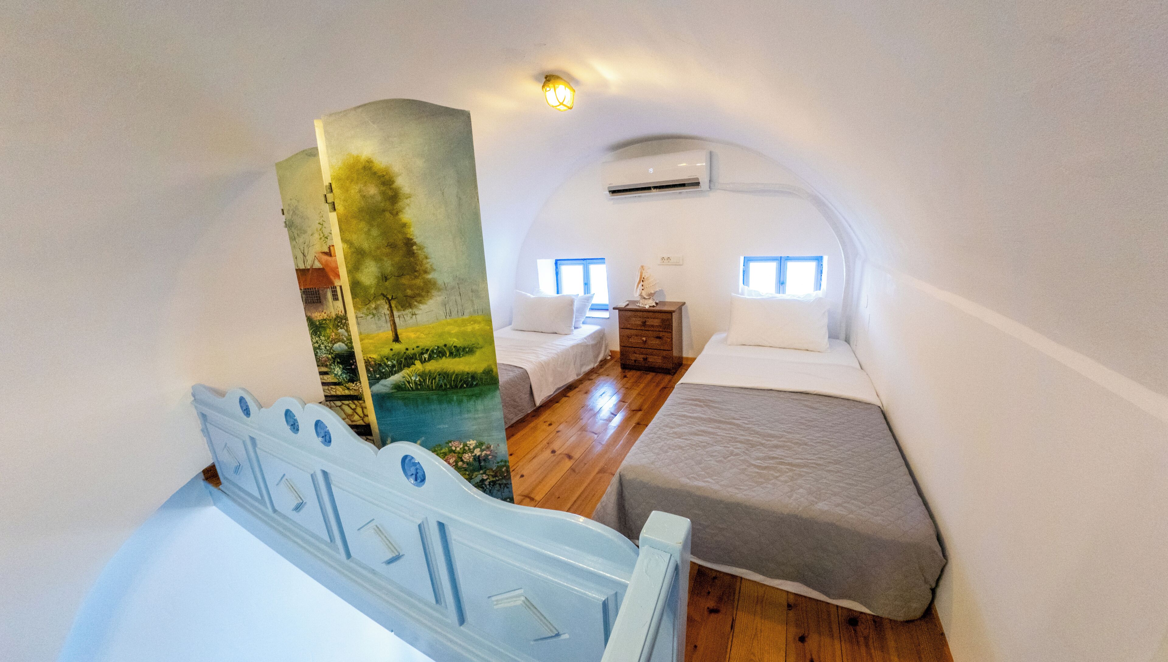 A bedroom with a bunk bed, a dresser, a nightstand, and a wall-mounted air conditioner.