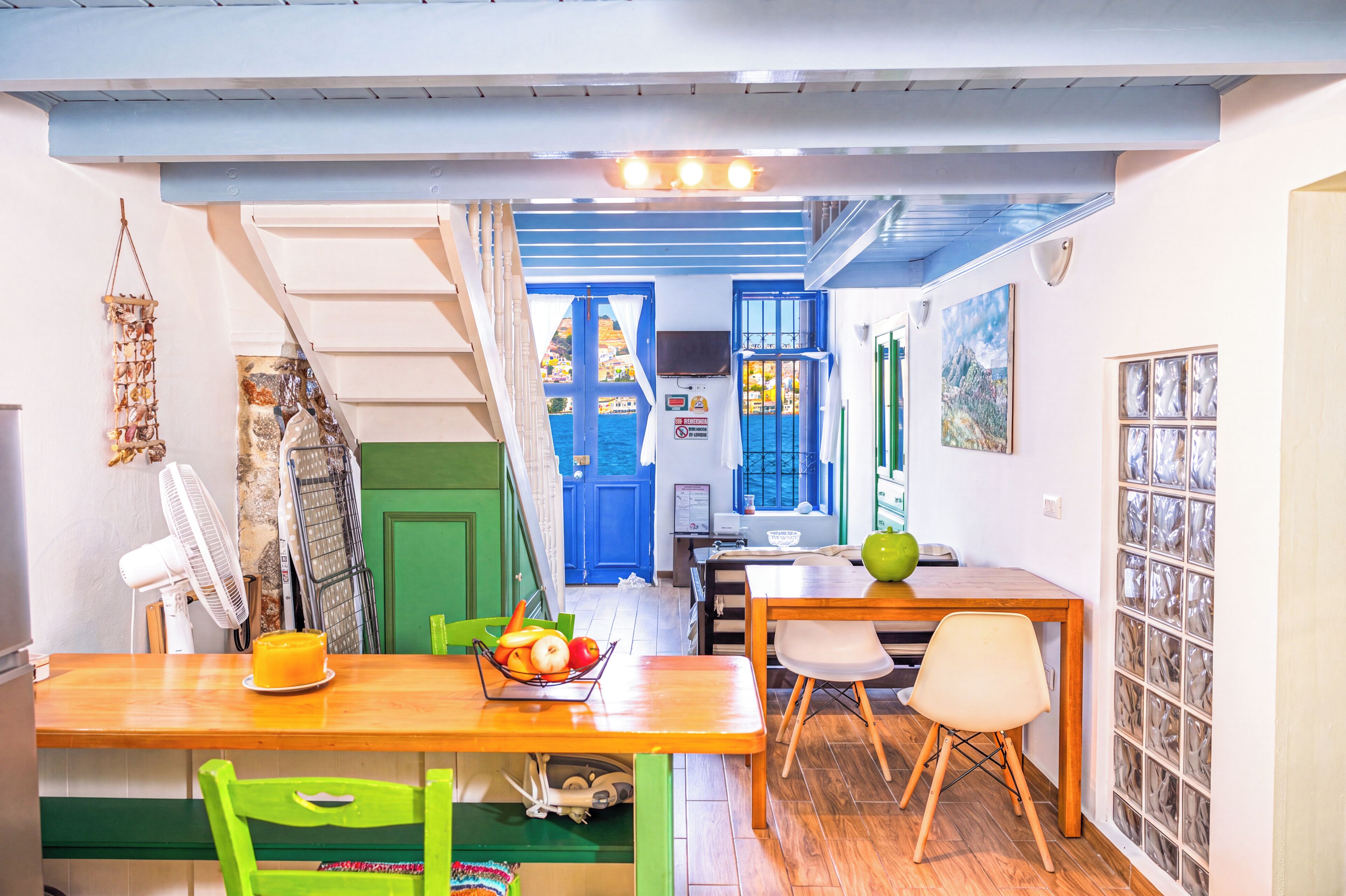A dining area with a table, chairs, and a fruit bowl.