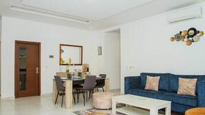 Un soggiorno moderno con un divano blu, un tavolo da pranzo in legno e un tavolino.
