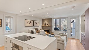 Een moderne keuken met een centraal eiland, een ingebouwde oven en een eethoek met open haard.