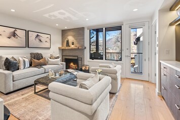 Spacious living room featuring a contemporary update, complete with new plush high end furniture, and the warmth of a wood-burning fireplace.