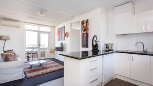 A modern apartment with a kitchen, living area, and a balcony.