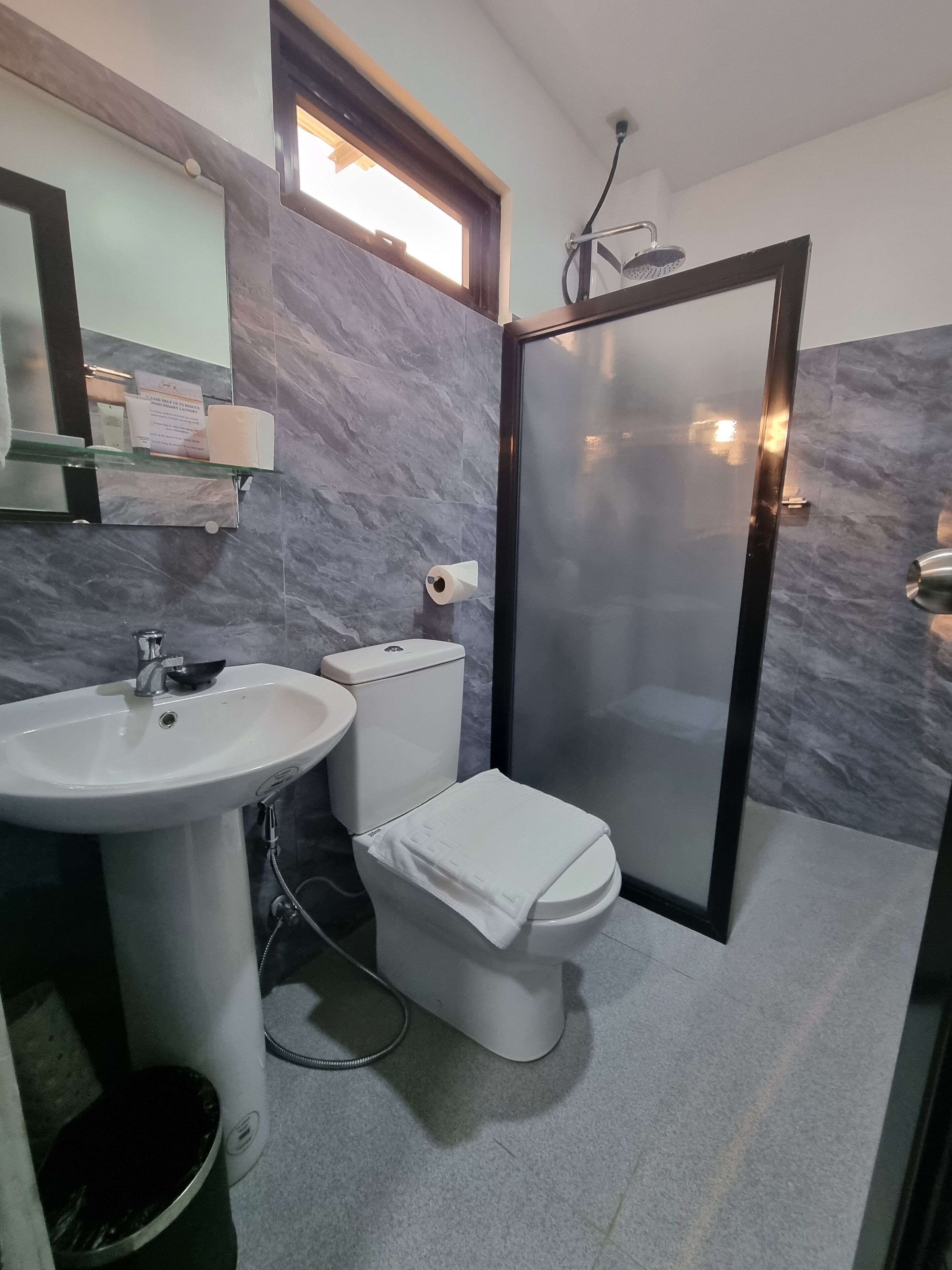 Un baño moderno con lavamanos, inodoro y cabina de ducha blancos.