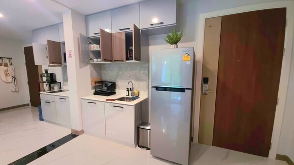 A modern kitchen with white cabinets, a stainless steel refrigerator, and a sink. - Ao407- 2 Bdr Condo With Forest View, Ao Nang Beach (Krabi)