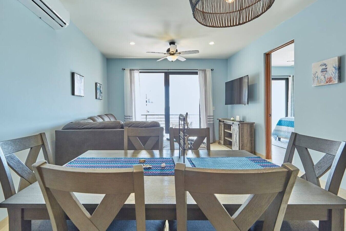 A dining area with a table and chairs, a ceiling fan, and a view to the outside.