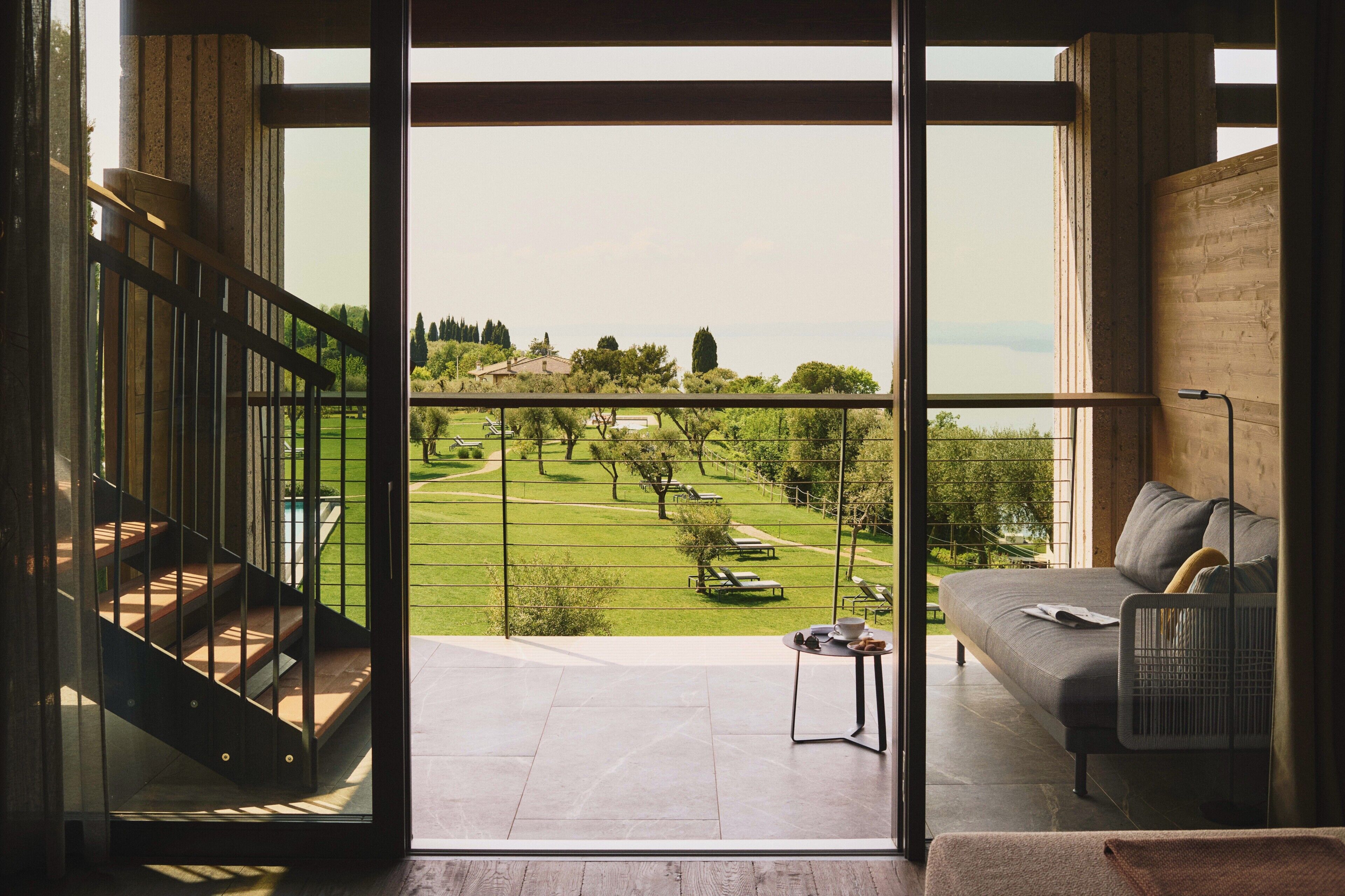 A modern interior with a balcony, a sofa, and a table.