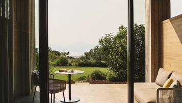 Un espace extérieur aménagé avec une table et des chaises, un canapé et une vue sur un jardin paysager.